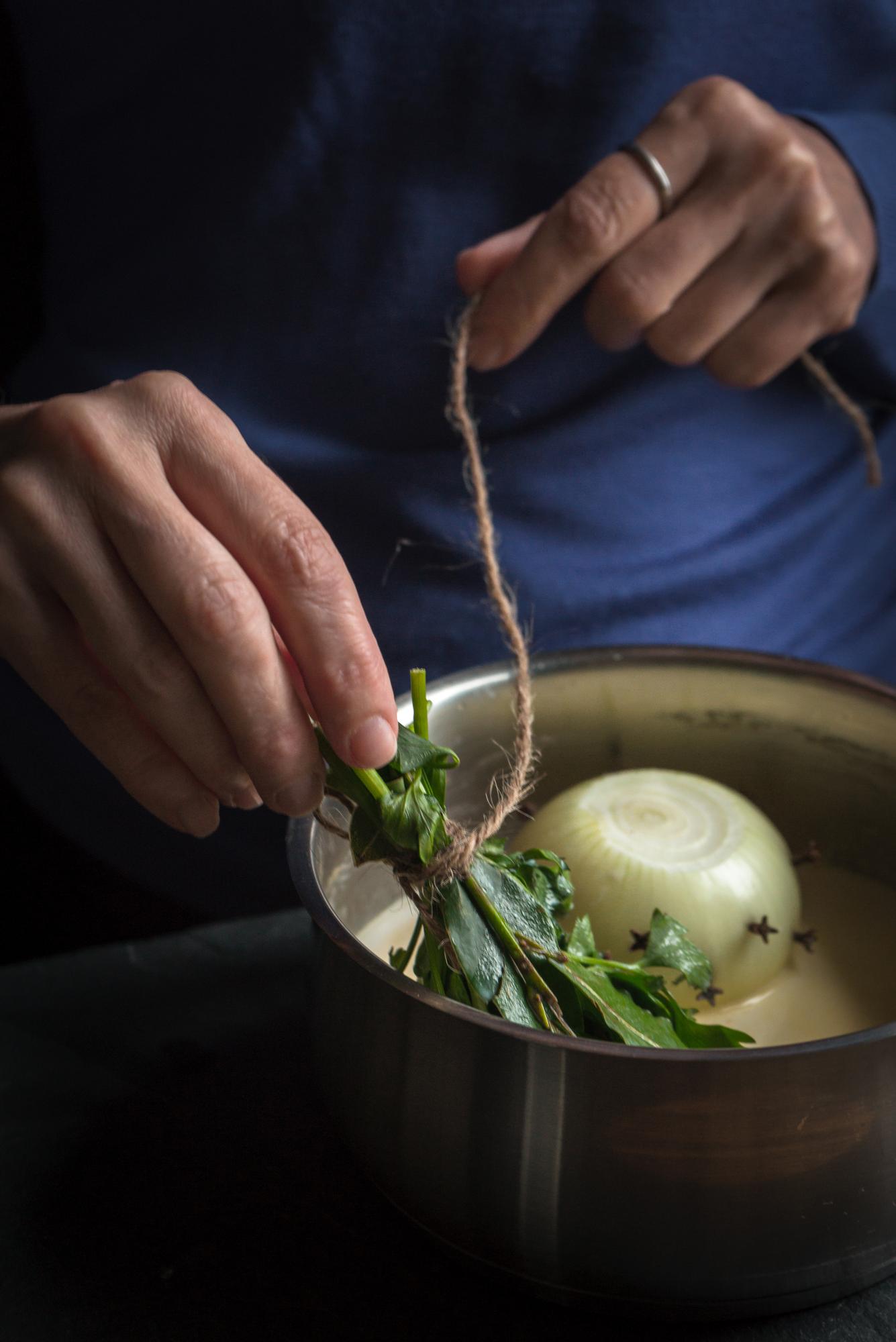Chef arranging herbs on ceramic plate