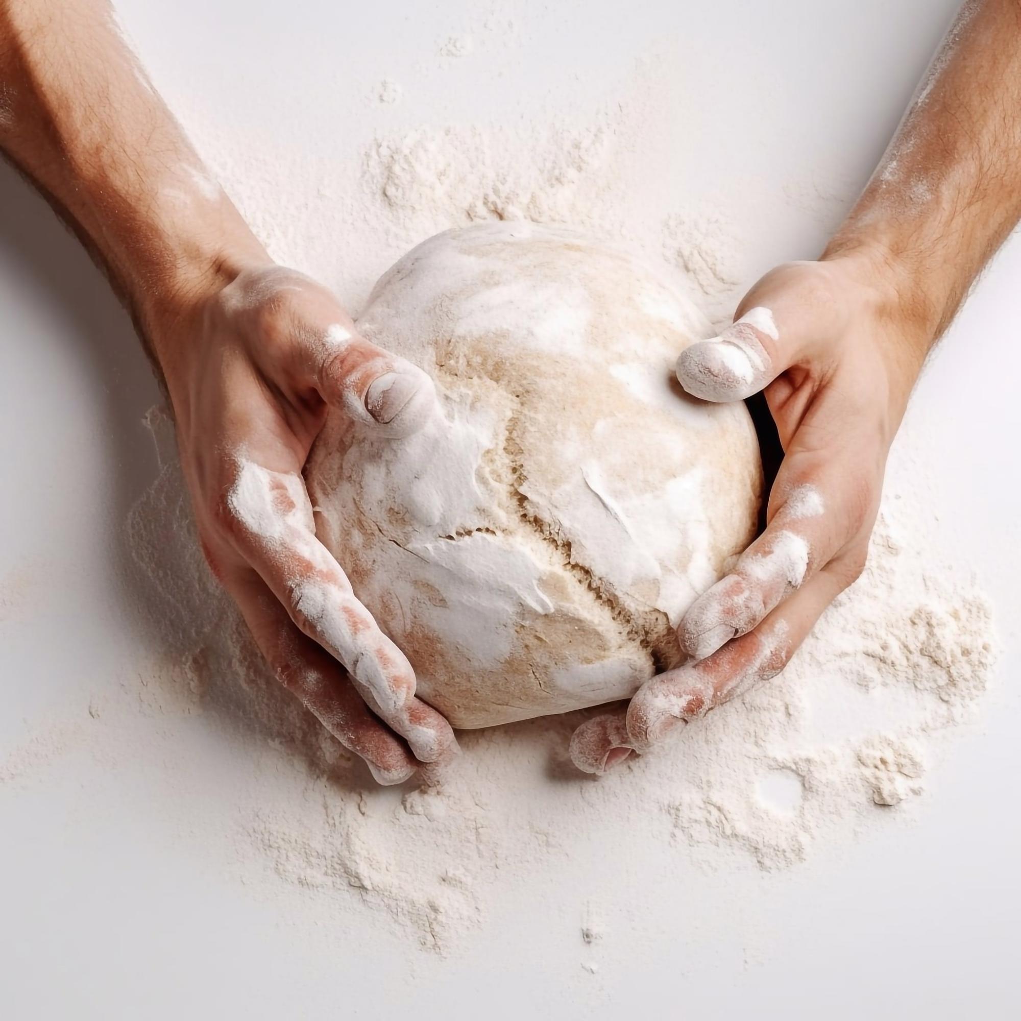 Hands kneading dough in warm kitchen light